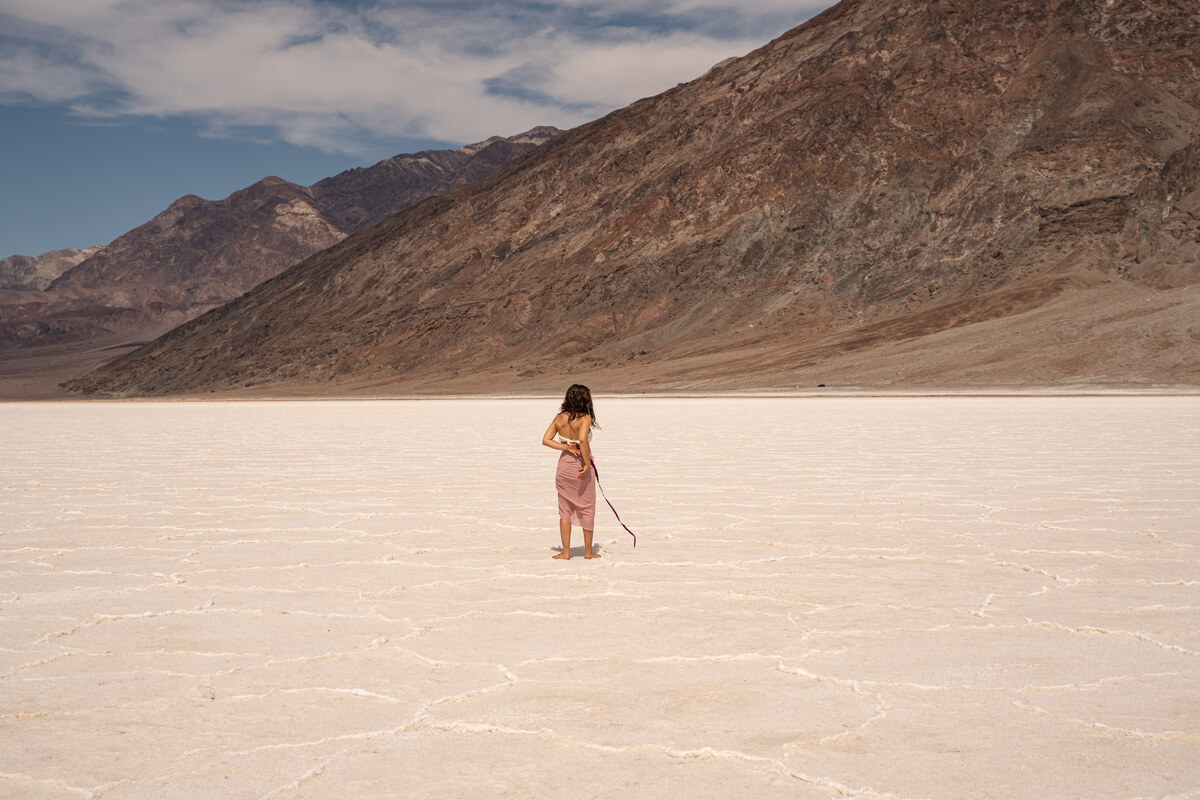 Melissa turned away from the camera on the salt flats, facing the mountain landscape.